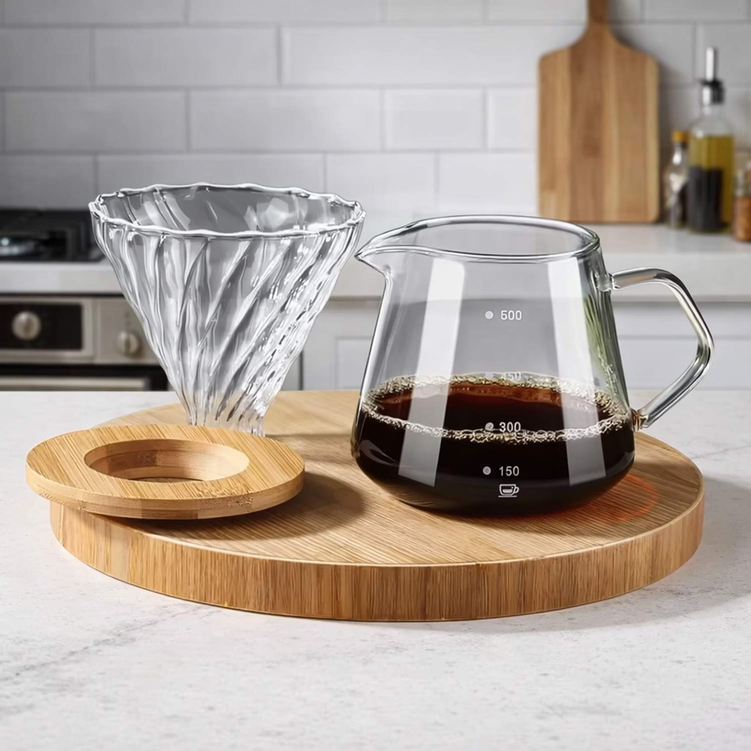 Glass pour over coffee maker set with glass dripper and coffee carafe on bamboo tray in modern kitchen